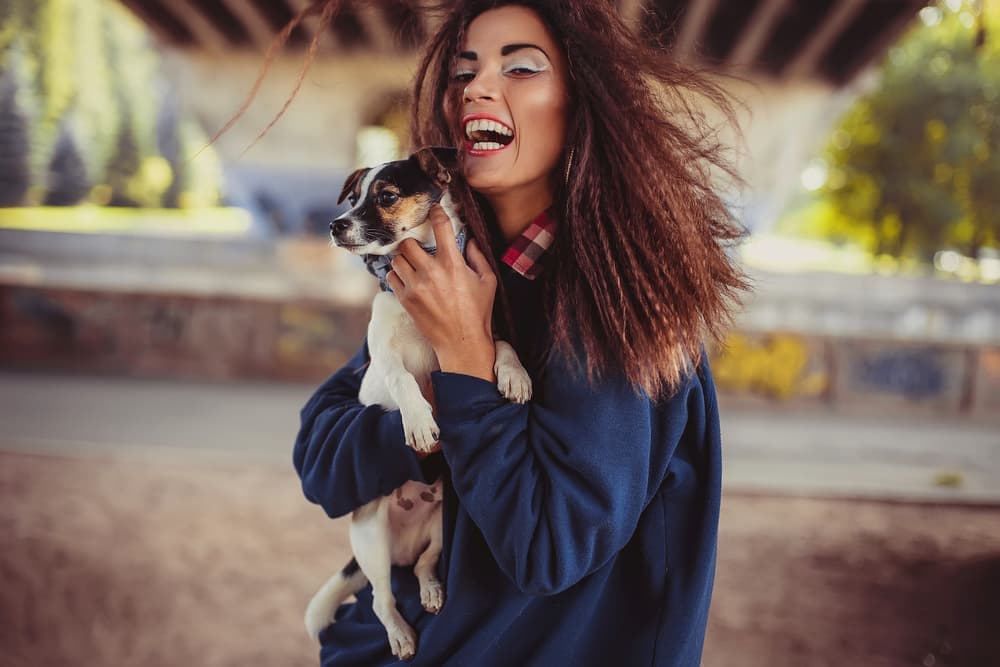 Dog being held by cute owner outside