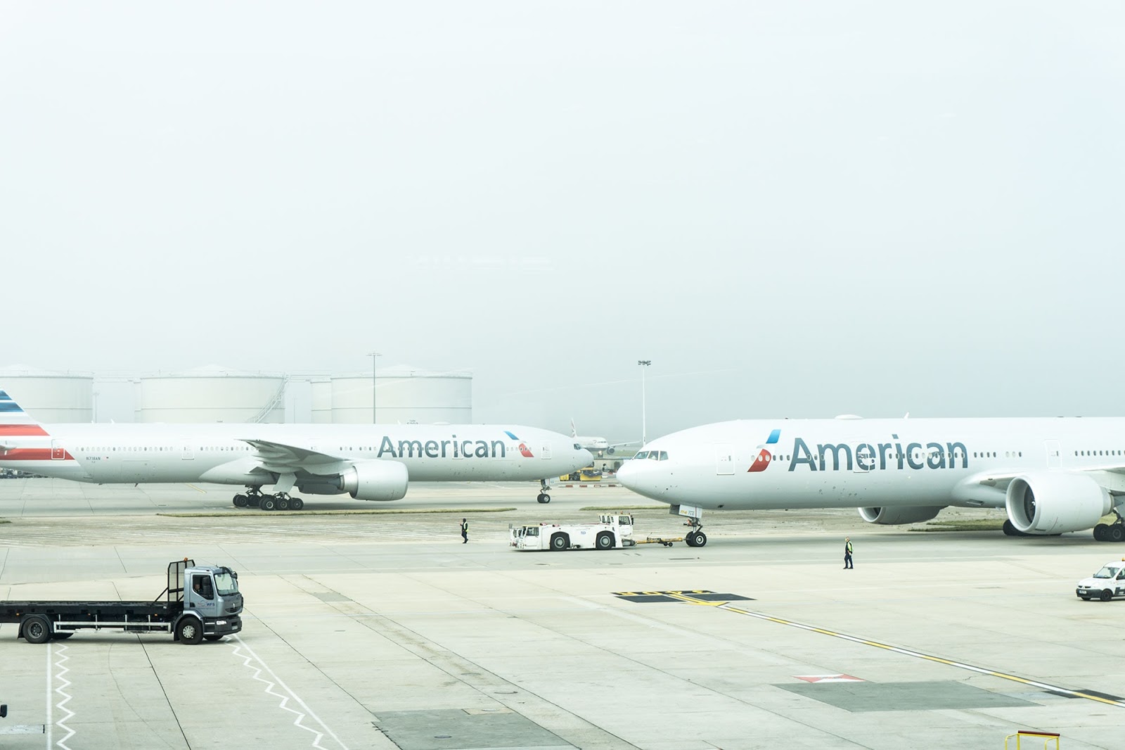 Two American airlines planes sit at the airport landing strip